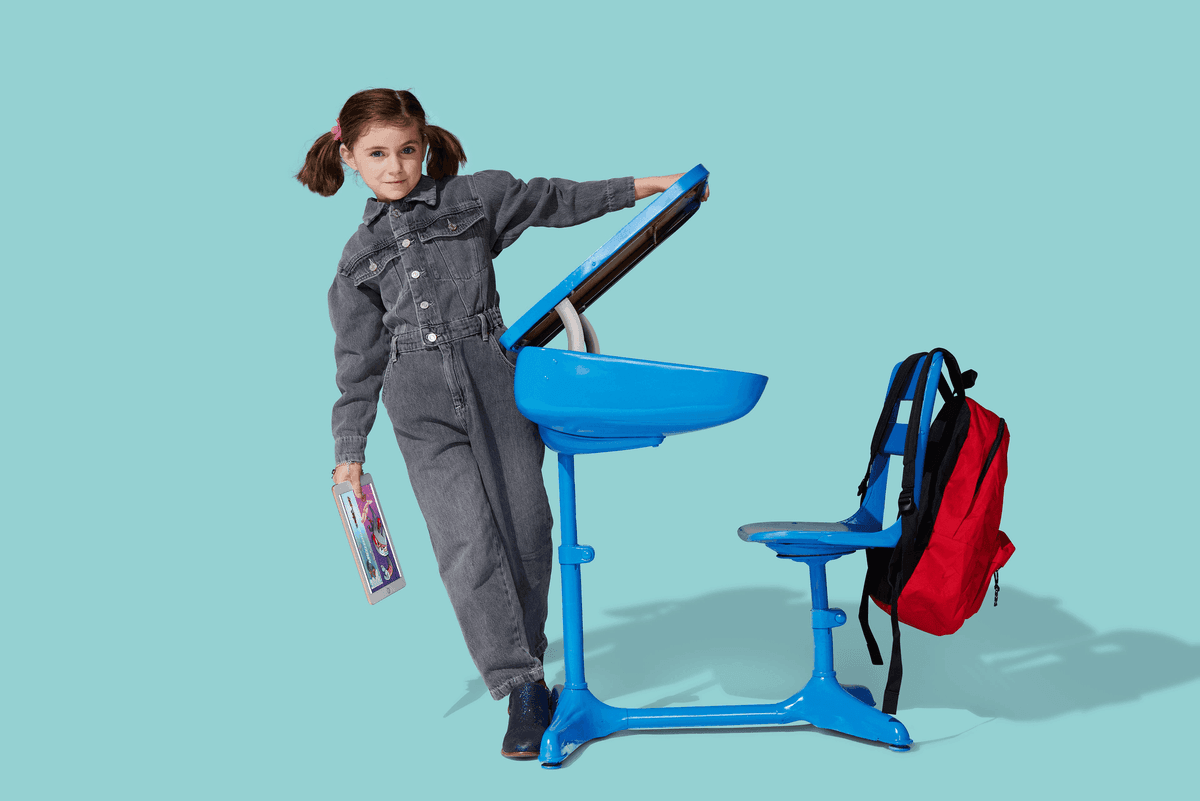 Child at blue desk with backpack