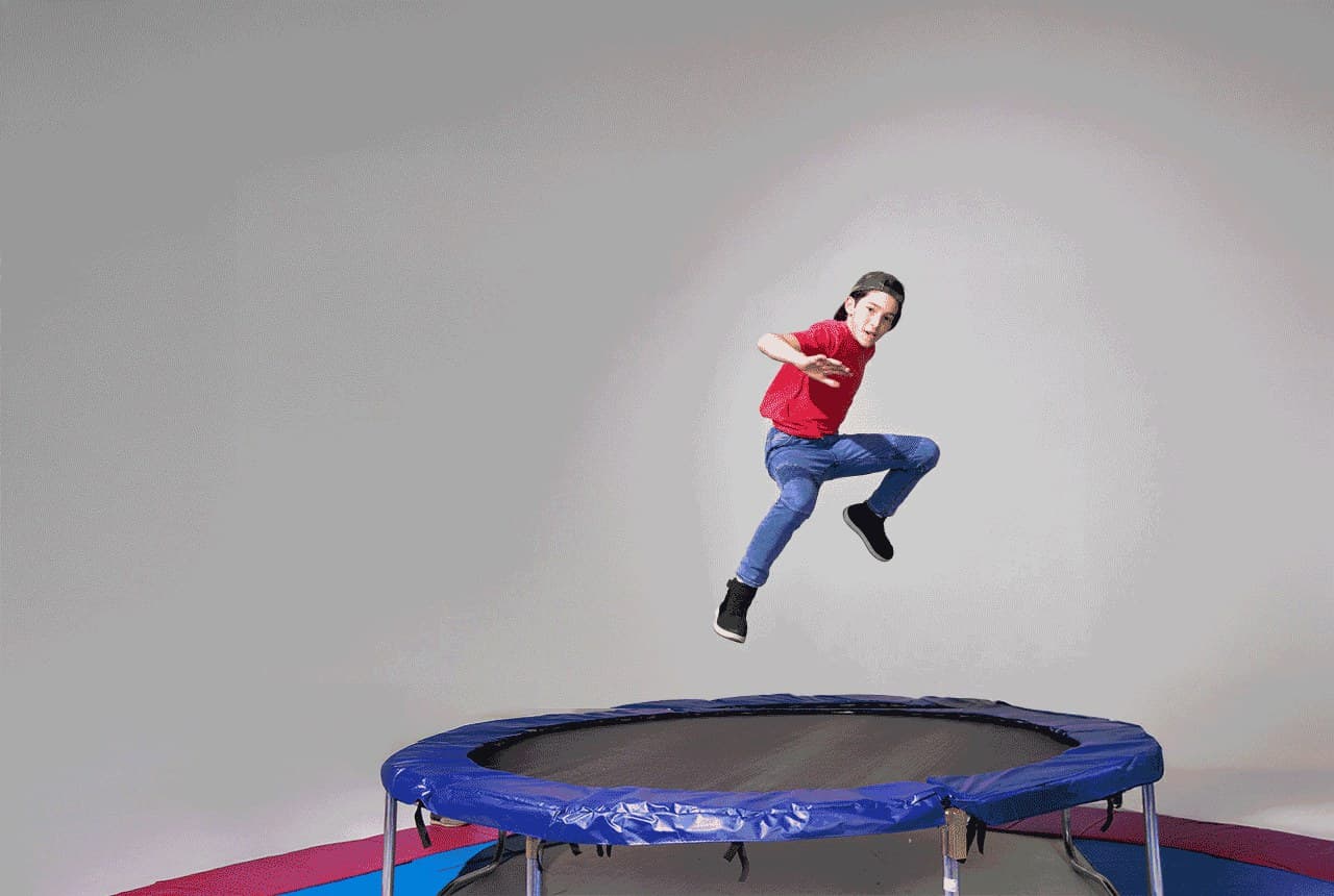 Raw studio shot of a boy jumping on a trampoline
